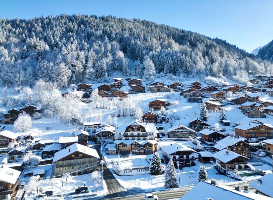 Discover the charm of a snow-covered village nestled in the mountains.