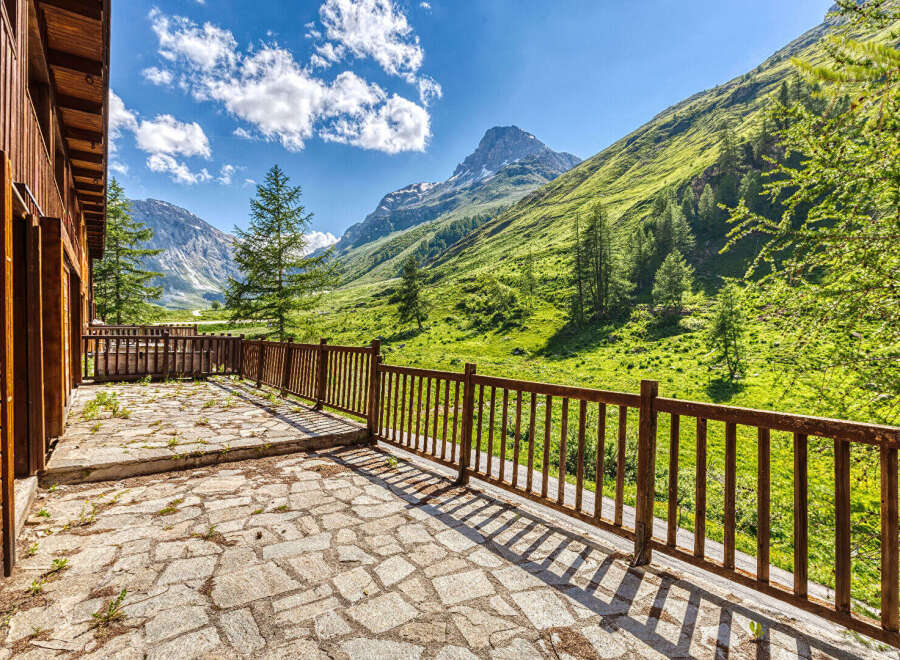 Experience breathtaking mountain views from the expansive stone patio of this charming wooden cabin.