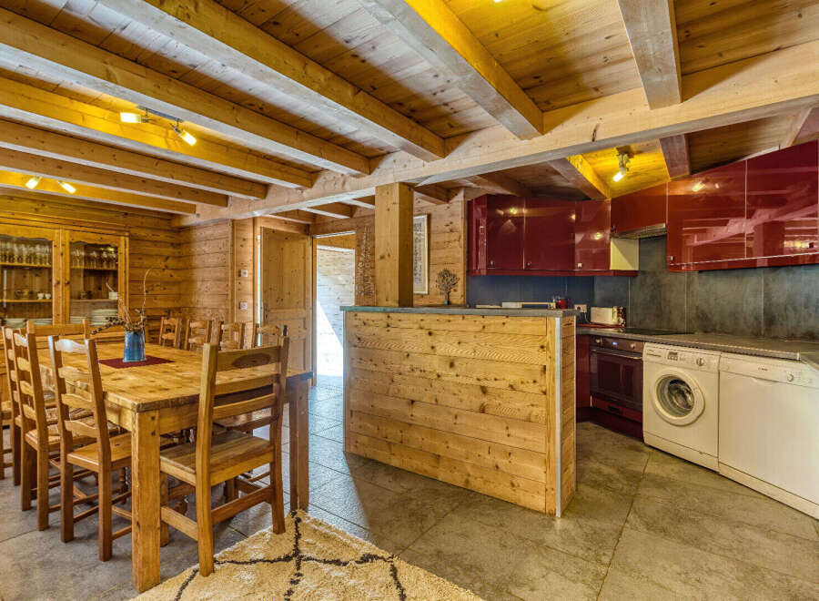 Experience rustic charm in this mountain chalet featuring a spacious wooden dining area perfect for family gatherings.
