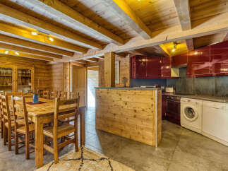 Experience rustic charm in this mountain chalet featuring a spacious wooden dining area perfect for family gatherings.