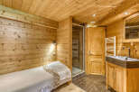 Experience rustic charm in this cozy bedroom featuring warm wooden walls and ceiling.