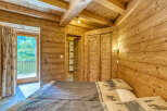 Experience rustic charm in this cozy wooden bedroom, featuring two comfortable beds adorned with nature-themed linens.
