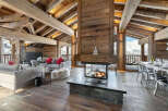 Experience luxury living in this stunning chalet, featuring a cozy fireplace and exposed wooden beams.