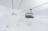 Experience the thrill of skiing with this stunning image of a ski lift amidst a snowy landscape.