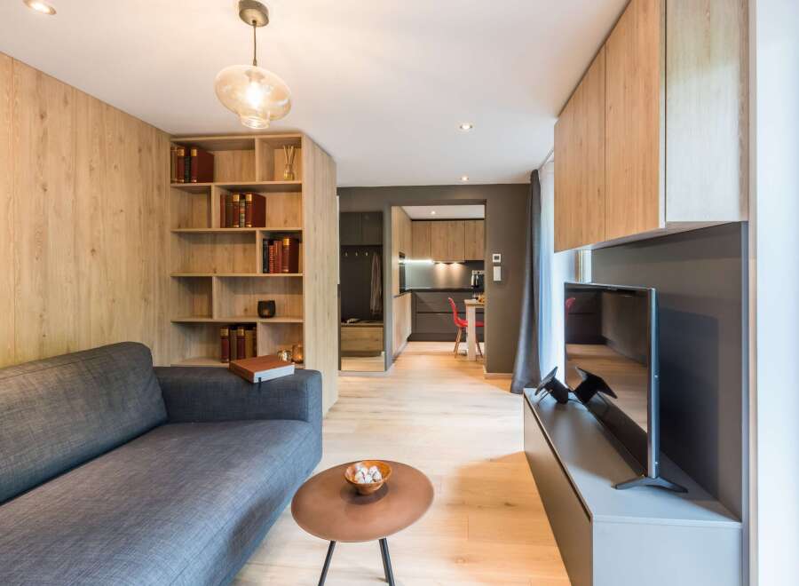 This modern living space features a sleek design with wooden accents and a cozy gray sofa.