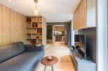 This modern living space features a sleek design with wooden accents and a cozy gray sofa.