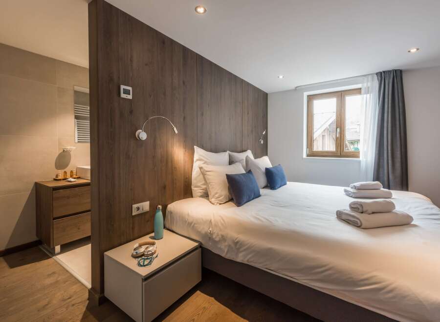 This cozy bedroom features a modern design with wooden accents and a comfortable bed.