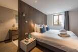 This cozy bedroom features a modern design with wooden accents and a comfortable bed.