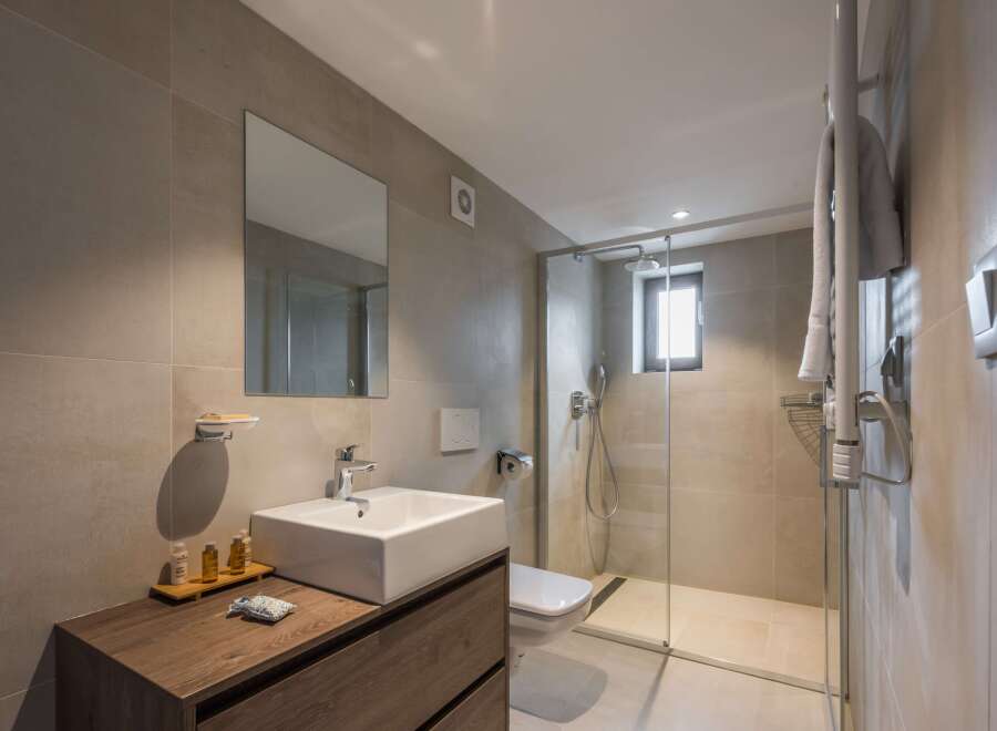 This modern bathroom features a sleek, minimalist design with a spacious walk-in shower.
