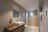 This modern bathroom features a sleek, minimalist design with a spacious walk-in shower.