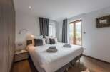 This cozy bedroom features a comfortable bed with soft linens and plush pillows, perfect for a relaxing stay.