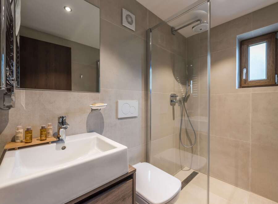 This modern bathroom features a sleek, minimalist design with a spacious walk-in shower.
