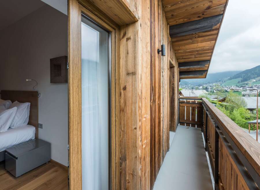 Experience the charm of this stunning property with its rustic wooden facade and inviting balcony.