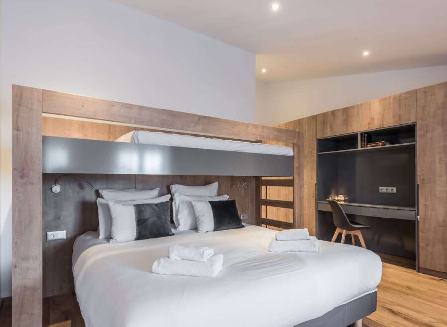This modern bedroom features a stylish bunk bed design, perfect for maximizing space.