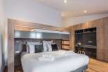 This modern bedroom features a stylish bunk bed design, perfect for maximizing space.