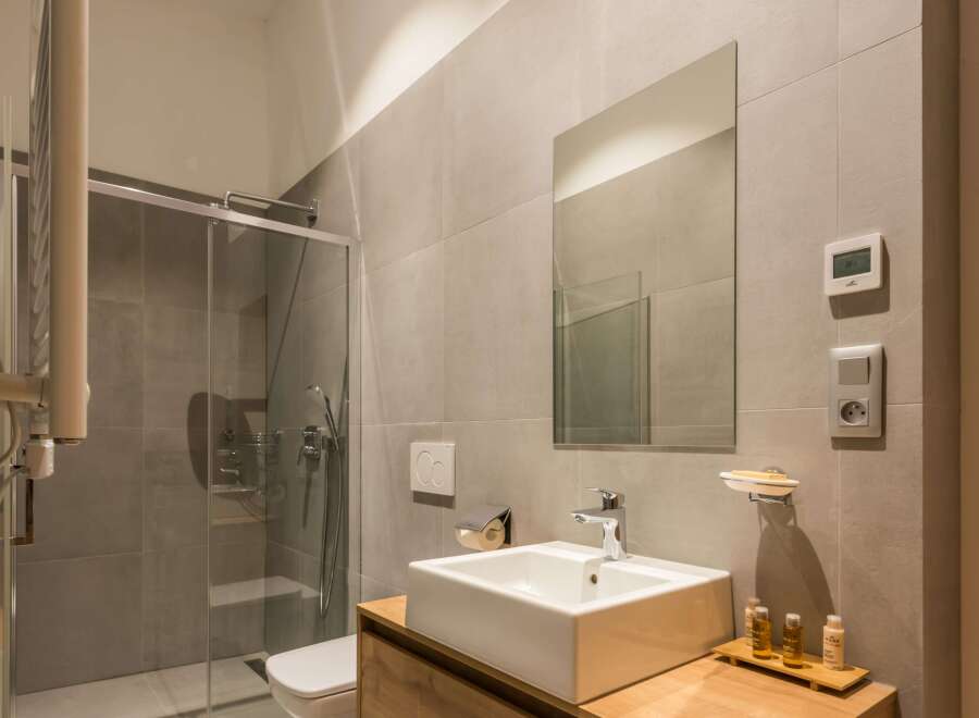 This modern bathroom features a sleek, minimalist design with a glass shower enclosure and a contemporary sink.