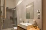 This modern bathroom features a sleek, minimalist design with a glass shower enclosure and a contemporary sink.