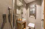 This modern bathroom features a sleek showerhead and a stylish towel warmer.