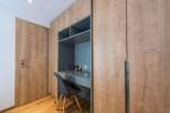 This stylish room features a custom-built desk and shelving unit, perfect for a home office or study space.