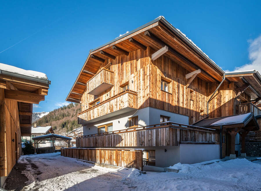 Discover the charm of this stunning wooden chalet nestled in a picturesque winter landscape.