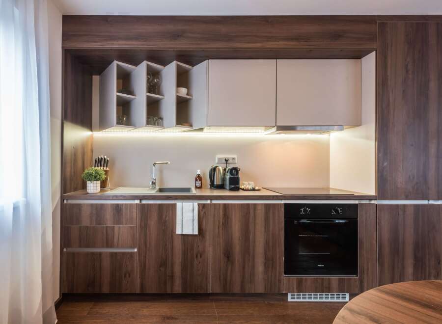 This modern kitchen boasts sleek, dark wood cabinetry and a minimalist design.