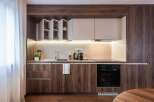 This modern kitchen boasts sleek, dark wood cabinetry and a minimalist design.