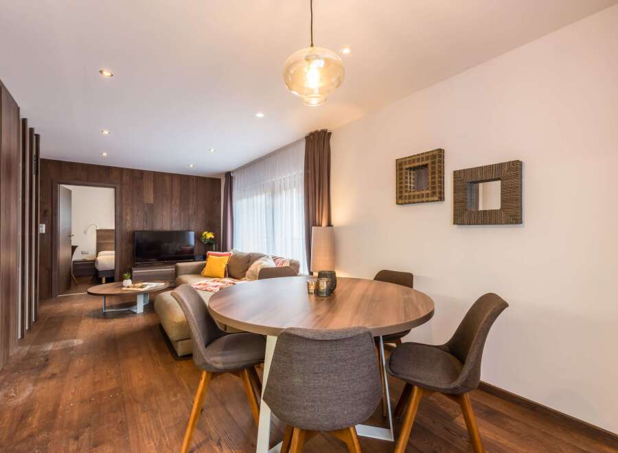 This stunning property boasts a modern living space with a cozy seating area and a dining table perfect for entertaining.