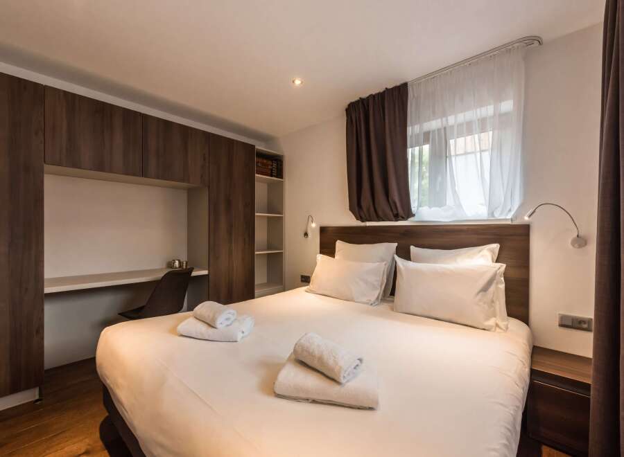 This cozy bedroom features a comfortable bed with fresh white linens and fluffy pillows.