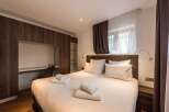 This cozy bedroom features a comfortable bed with fresh white linens and fluffy pillows.
