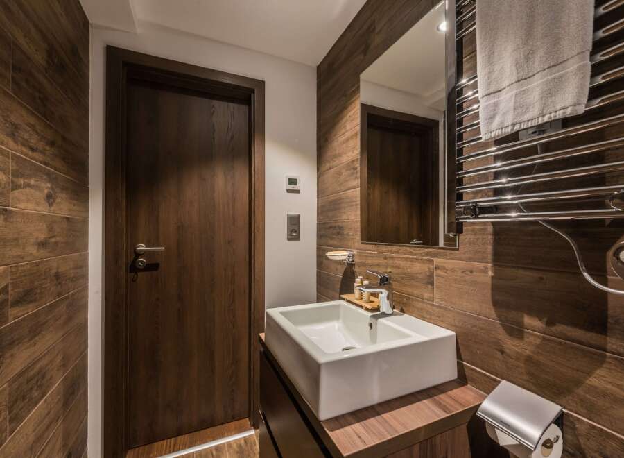 This modern bathroom features a sleek, minimalist design with a wooden accent wall.
