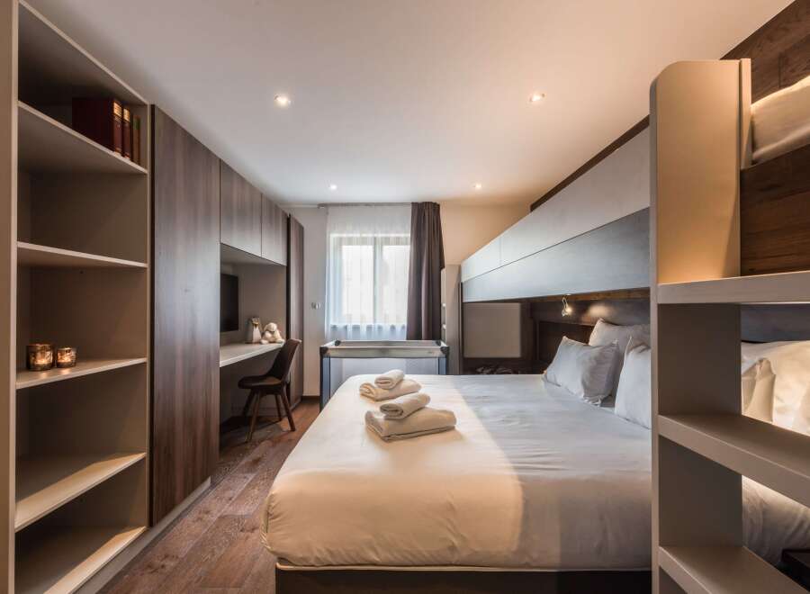 Discover a stylish and modern bedroom featuring a comfortable bed with fresh linens and fluffy pillows.