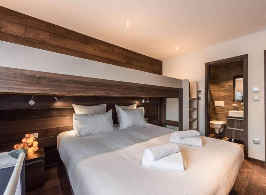This cozy bedroom features a unique bunk bed design with a modern aesthetic.