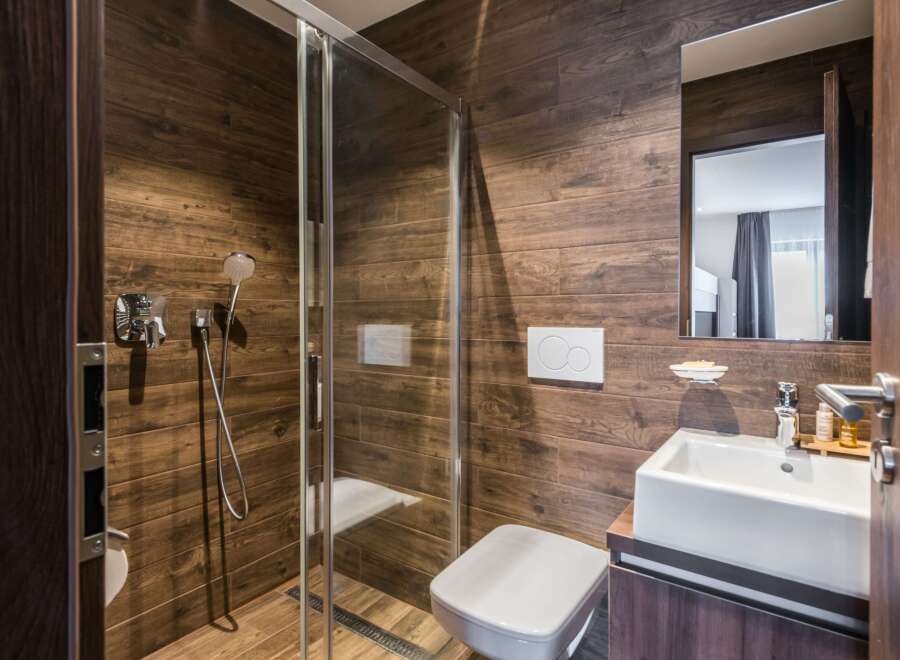 This modern bathroom features a sleek glass shower enclosure and a stylish white sink.