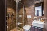 This modern bathroom features a sleek glass shower enclosure and a stylish white sink.