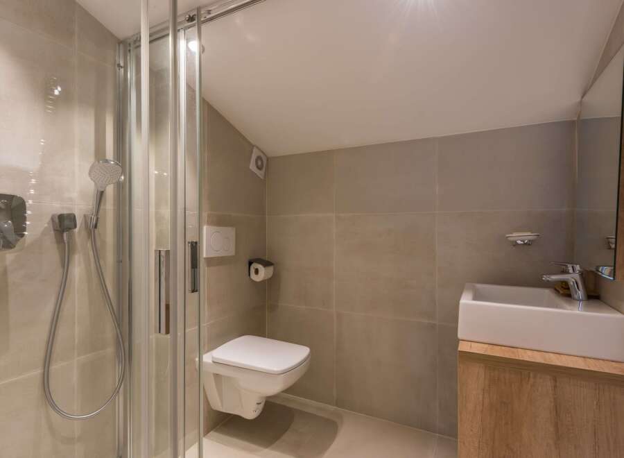 This modern bathroom features a sleek shower enclosure and a minimalist design.