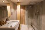 This modern bathroom features a sleek glass shower and a stylish sink area.