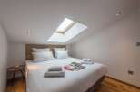This cozy bedroom features a skylight, allowing natural light to flood the space.