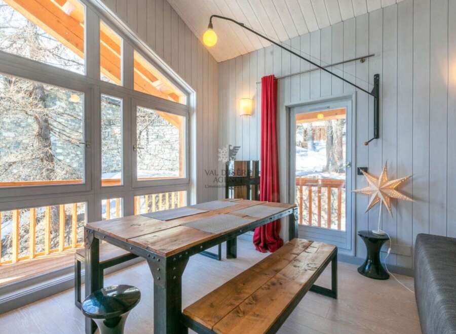 This stunning chalet boasts a spacious dining area with a rustic wooden table and benches, perfect for enjoying meals with breathtaking views.