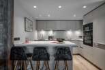 Modern kitchen with sleek gray cabinets and integrated appliances.