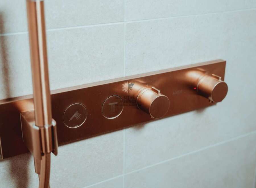 Luxury bathroom featuring a sleek, copper-finished shower system with integrated controls.