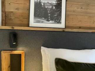 Cozy up in this charming bedroom featuring a stunning black and white mountain landscape print.