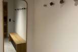 This entryway features a stylish wooden bench and a large mirror, perfect for a quick check before heading out.