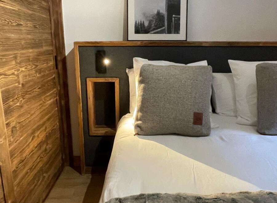 Cozy up in this stylish bedroom featuring a comfortable bed with plush pillows and a luxurious faux fur throw.