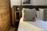 Cozy up in this stylish bedroom featuring a comfortable bed with plush pillows and a luxurious faux fur throw.