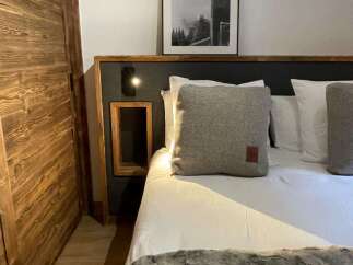 Cozy up in this stylish bedroom featuring a comfortable bed with plush pillows and a luxurious faux fur throw.