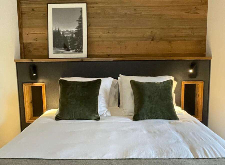 Cozy bedroom with a rustic wooden headboard and a framed black and white picture.