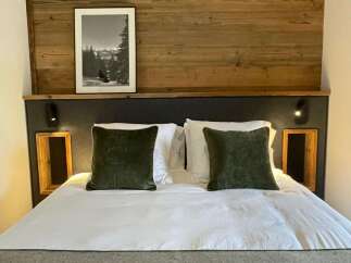 Cozy bedroom with a rustic wooden headboard and a framed black and white picture.