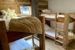 Cozy up in this charming bedroom featuring rustic wooden bunk beds, perfect for a family getaway.