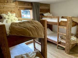 Cozy up in this charming bedroom featuring rustic wooden bunk beds, perfect for a family getaway.
