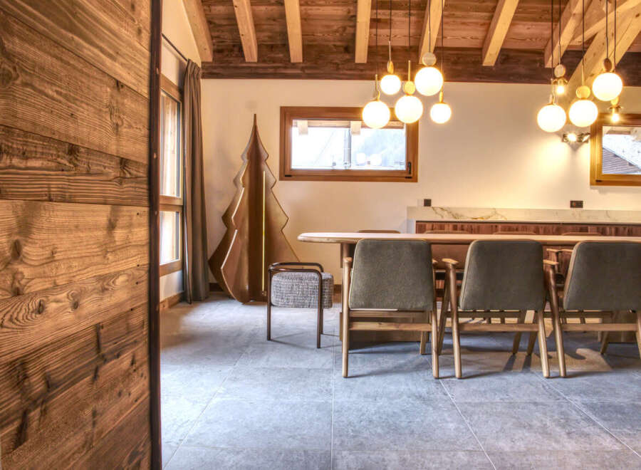 Experience the warmth of this inviting dining area, featuring a stunning wooden ceiling and elegant globe pendant lights.